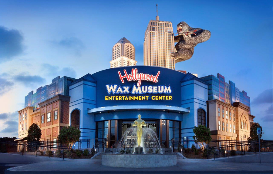 Exterior of the Hollywood Wax Museum at night showcasing the custom signage, giant sculpted skyscrapers and gorilla