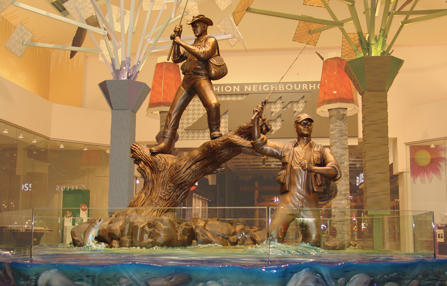Custom bronze sculptures of fishermen in a mall's public art display