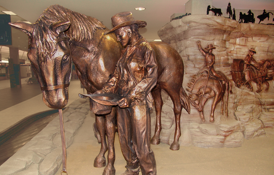 Museum exhibit showcasing custom bronze sculptures of cowboys, horses and badlands
