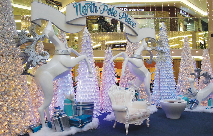 Christmas themed mall décor with sculpted reindeer, trees and ribbon signage