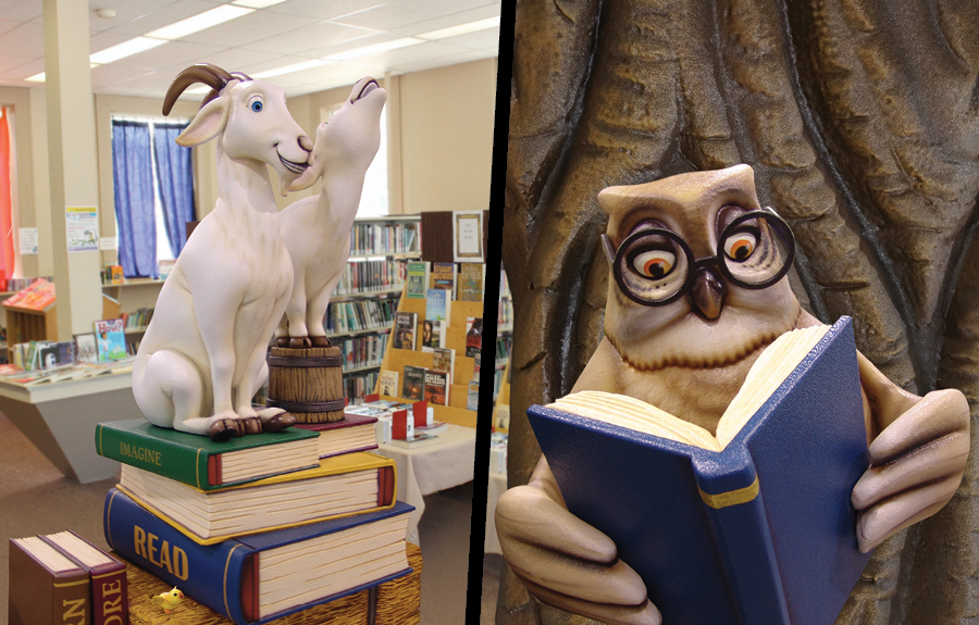 Sculpted giant books with goat characters and a reading owl in a kids library