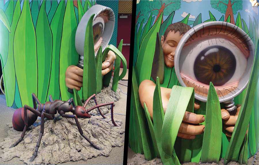 Giant 3d foam ant, grass, and magnifying glass in a kids science centre