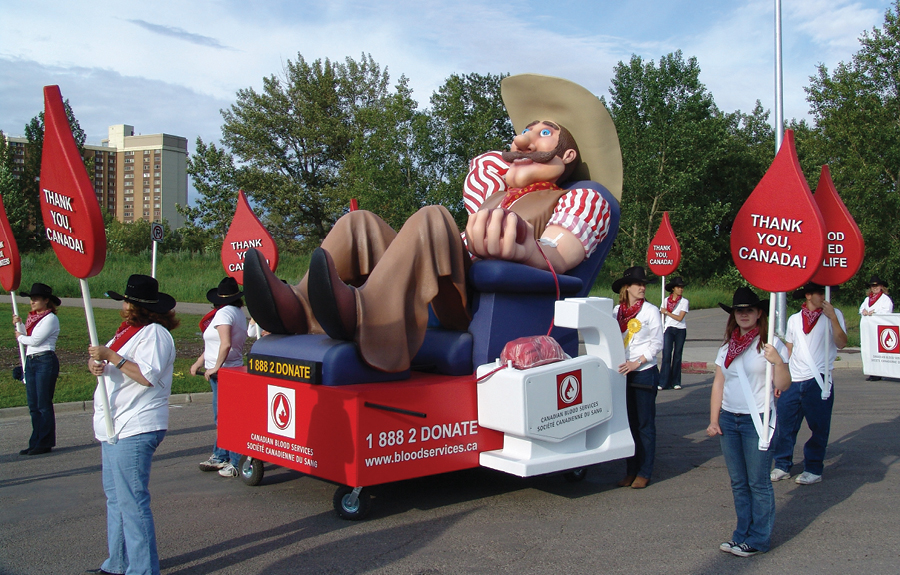 Stampede Parade float for Canadian Blood Services with a sculpted cowboy character giving blood