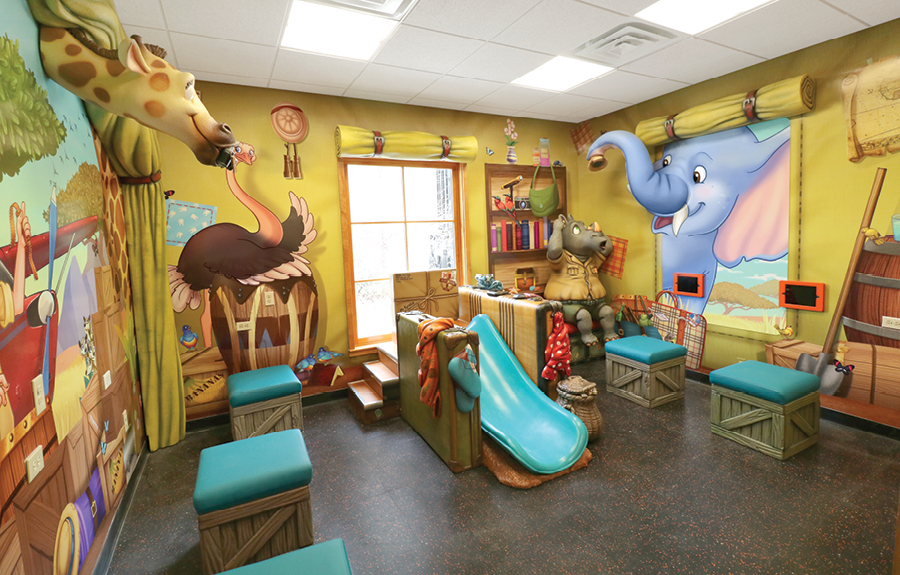 Safari adventure themed kids play area with sculpted animals, stools and custom murals